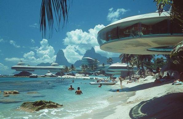 Futuristic coastal dish shaped properties on beach with palms and sunshine
