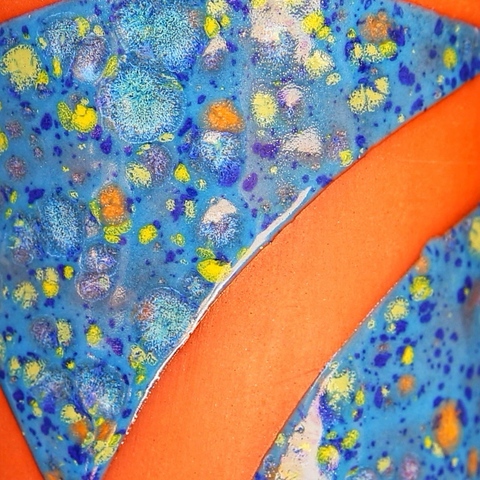 Close-up sur l’émaillage et une large bande sans émaux laissant apparaître la couleur de la terre 