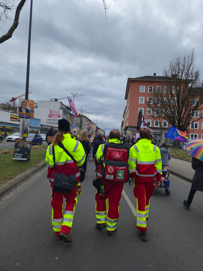 3 Demosanitäter*innen am ende Demo einer Trägt einen Rettungsrucksack.
