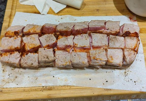 Partially cooked pork belly that has been scored with dry rub and bean paste