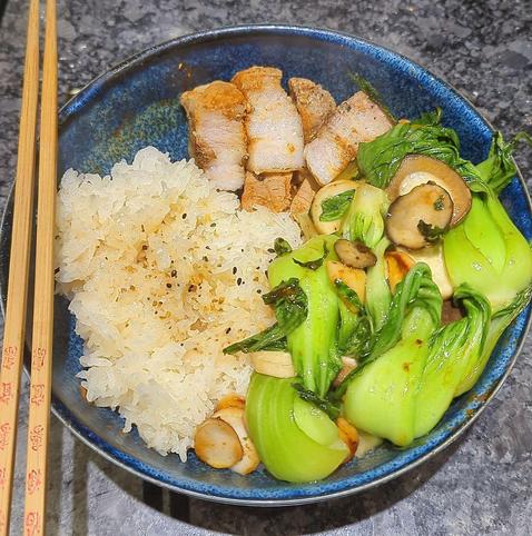 Blue bowl with sticky rice, baby Bok Choy, king oyster mushrooms, and some cubed pork belly