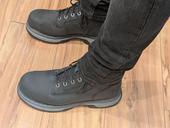 A man wearing black jeans and black composite toe safety shoes