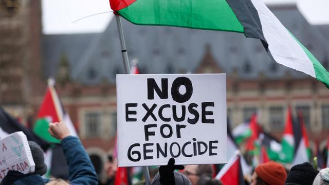 A demonstration with palestinians flags and a text that says "No excuse for genocide".