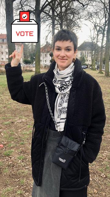 Frau zeigt mit dem Finger auf eine Grafik "ein Wahlbox mit der Aufschrift Vote"
