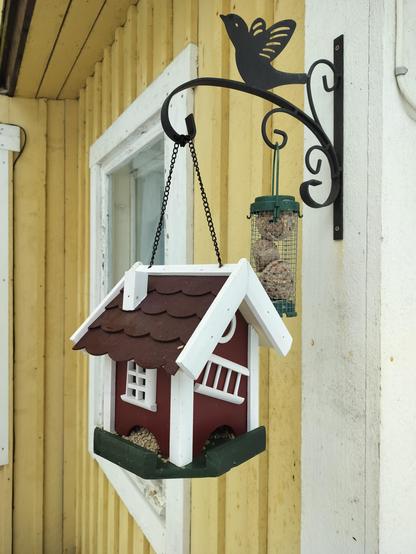 Seeds for birds and squirrels inside the tiny red wooden house. 