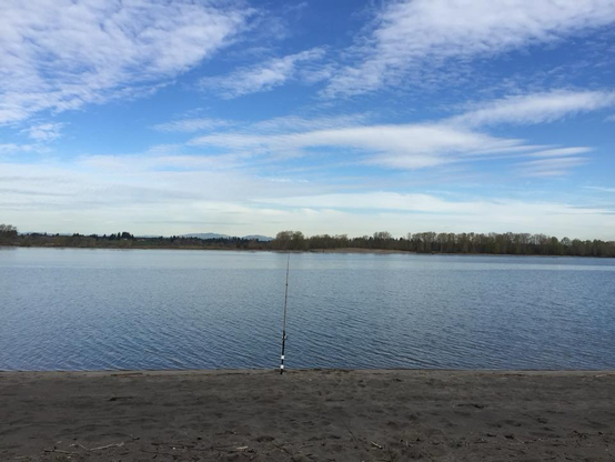 A picture of blue sky above the Columbia River with a suspended fishing pole quietly waiting for a Spring Chinook. 