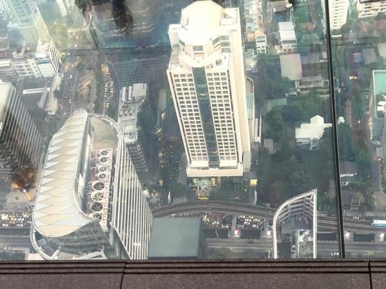 Beim Skywalk sieht man auf dem Balkon mit Glasboden über 300 Meter in die Tiefe, mit Blick auf die Hochhäuser.