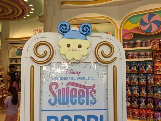Sign telling you that you're entering Disney Wonderful World of Sweets with logo of a popcorn popped kernel with Mickey ears.