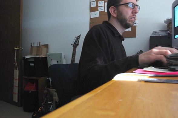 Photo of Pete working at a desk using a computer.