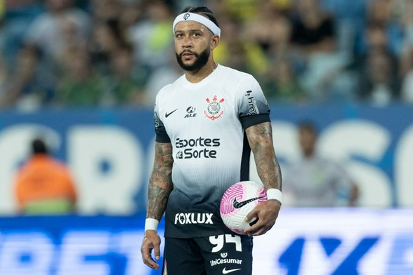 Foto do Menphis Depay com a camisa do Corinthians segurando uma bola.