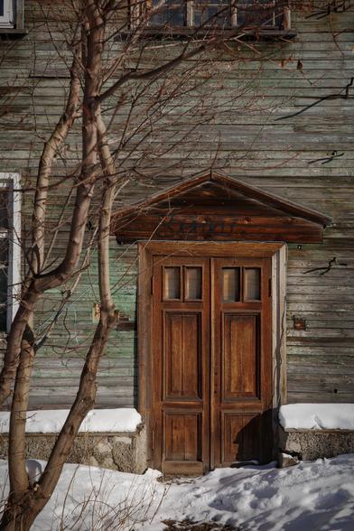 In the photo, an old house with an old door is a beautiful combination of textures and colors.