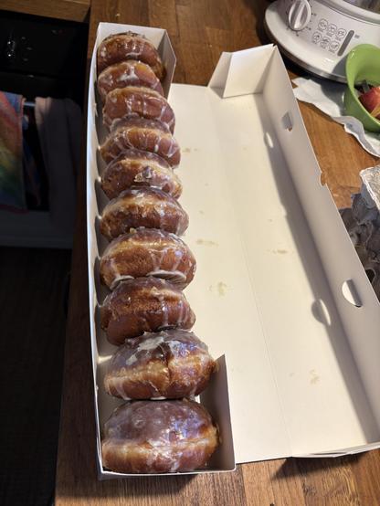 Caja alargada con los tradicionales donuts polacos colocados en fila