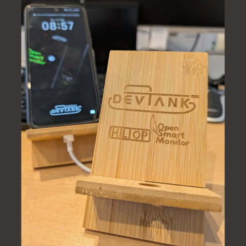 wooden phone stand embossed with three logos - devtank, hiltop, and opensmartmonitor