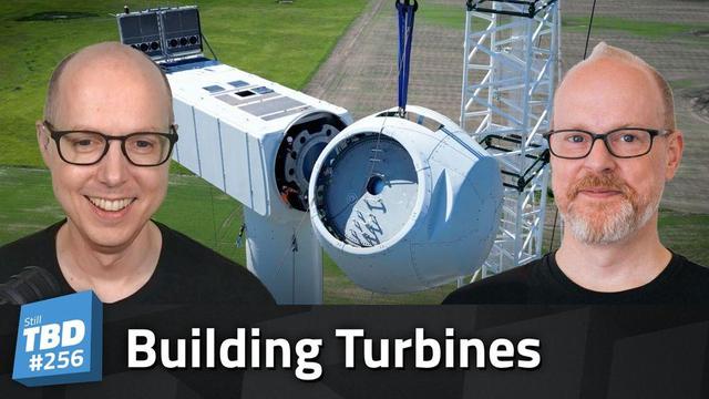 Matt and Sean Ferrell in front of a wind turbine under construction
