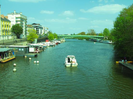 Navires de plaisance fluviaux, et un pont vert au loin