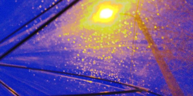 Au travers un parapluie transparent, la lumière d'un lampadaire et les gouttes de pluie.

Through a transparent umbrella, the light of a street lamp and raindrops.