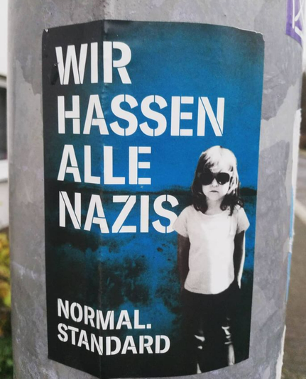 blauer Aufkleber, rechts unten kleines Mädchen mit Sonnenbrille, weißem T-Shirt, Hose. Großer Text auf Aufkleber: WIR HASSEN ALLE NAZIS. Kleiner darunter: NORMAL. STANDARD