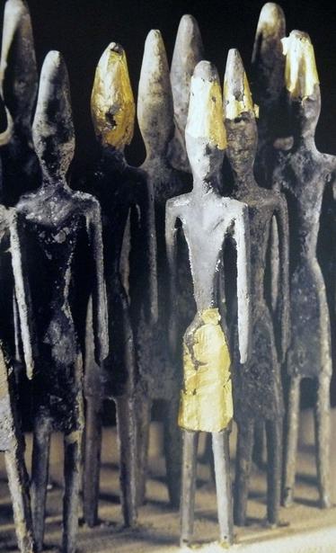 Estatuillas con apenas detalles, salvo la falda y el gorro cónico, ambos dorados. El resto de la figura es negra. En otras no presentes en la imagen, tienen otro gorro menos prominente y algún arma.
