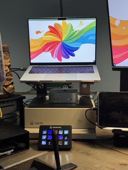 An Apple IIGS serves as the base, supporting an M4 Mac mini and M1 MacBook Pro. In front is a StreamDeck and an iPad mini.