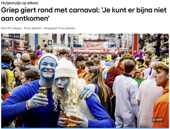 Een foto van een drukke straat vol verklede mensen, met op de voorgrond twee blauw geschminkte jongens in Smurfenkostuum met biertjes in de hand.