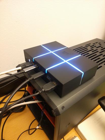 View slightly from upper left of Jolla Mind2 on top of desktop GPU tower machine laying down. Cables running to the left and air vents running to right in same direction as Mind2 front-back parallel LEDs.