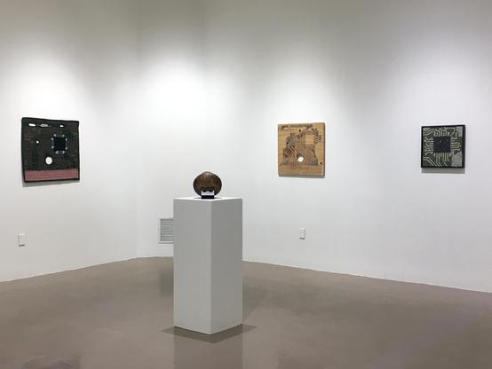 Installation view of Laura Memories of the Future exhibition at McIntosh Gallery, showcasing innovative artworks in quilt, woodcut relief and mosaic (left to right)