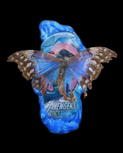 Digital collage of photos cutouts : a blue piece of melted plastic, a blue avengers flipflop, a blue damaged morpho butterfly, on a black background. Aluminim art print, 16x20 inches