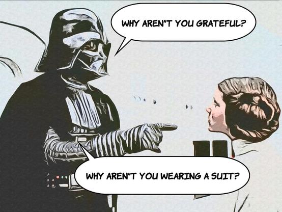 Scene from Star Wars. Darth Vader is pointing his finger at Princess Leia, right after her capture. He is asking, “Why aren’t you grateful? Why aren’t you wearing a suit?”