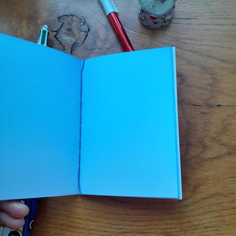 Intérieur de carnet A6 en papier de récupération, couverture linogravée et reliure au point de chaînette