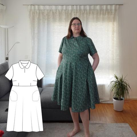 Photo of a woman in a green shirtwaist dress covered in drawings of little elephants. The dress has a Peter Pan collar, short sleeves and a half circle skirt. On the left is a line drawing of the pattern. The woman has her hands in the pockets.