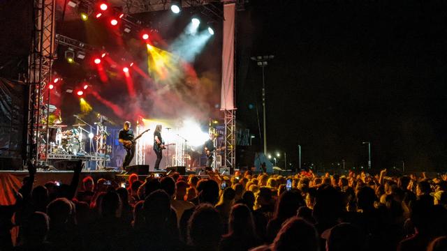 Shihad live in Christchurch. Evening shot from left side of the stage. Band playing, crowd enjoying themselves.