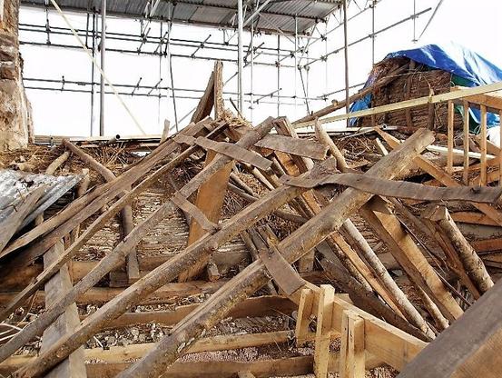 Reroofing in progress with new wood over the old.