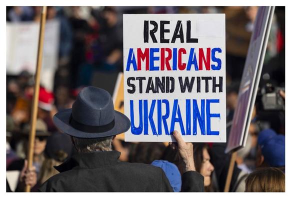 This s a colour photo of a protester holding a hand made sign which read ‘Real Americans Stand With The Ukraine’ This photo was found on the internet. A picture can say a thousand words!