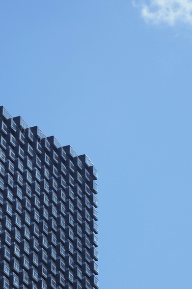 Tall apartment building structured in rectangular blocks that makes it look similar to an isometric grid. 