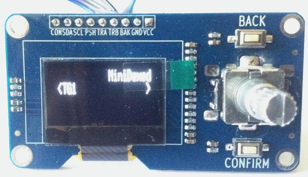 Photo of an approx 65x53mm module with a white OLED display and on the right hand side a rotary encoder and two buttons.
Display shows "MiniDexed" and "TG1".