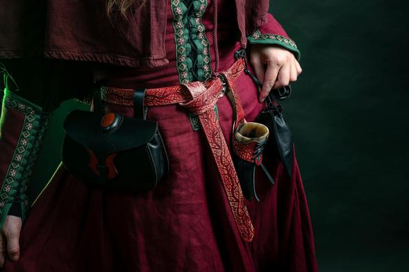 Detail shot of vegtan leather belt accessories: embossed belt and horn stand, belt bag with a red jasper insert, viking purse (based on a Hedeby finding).