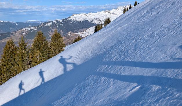 3 ombres de skieurs de randonnée à la montée sur une pente neigeuse