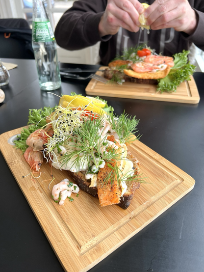 Det danske smørrebrød Stjerneskud med fisk og rejer serveret på surdejsbrød 