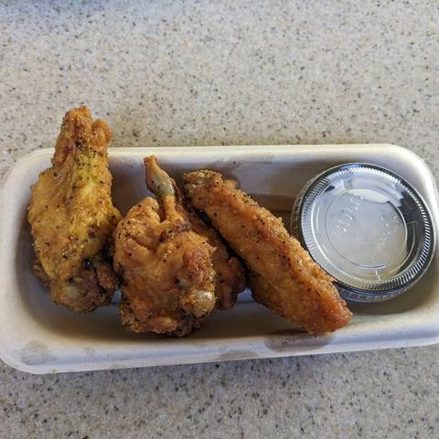 Chicken wings covered in lemon pepper seasoning with a side of ranch dressing with a hint of garlic flavor.