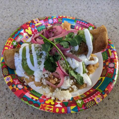 chicken taquito ahogado, served in salsa verde with Spanish rice, avocado crema, sour cream, pickled onion, cotija, and cilantro 