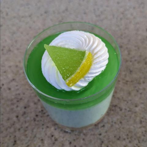 Top view of lime parfait - layers of graham cracker crust, lime cream cheese mousse, and lime-orange gelée topped with chantilly.