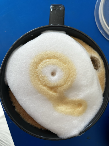 A cappuccino with an accidental summoning dark design
