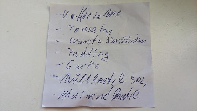 Bildbeschreibung von KI
Statt Müllbeutel 50l erkennt die KI Milch:

Das Foto zeigt einen handgeschriebenen Einkaufszettel auf einem kleinen, leicht zerknitterten Stück Papier. Die Schrift ist in blauer Tinte verfasst und wirkt etwas unregelmäßig. Die Einkaufsliste enthält verschiedene Lebensmittel, darunter:  

- Kaffeesahne  
- Tomaten  
- Wurst & Bierschinken  
- Pudding  
- Gurke  
- Milch (500 ml)  
- Mini-Windbeutel  

Das Papier liegt auf einer weißen Oberfläche, möglicherweise einem Tisch oder einer Küchenarbeitsplatte. Es gibt einige leichte Schatten und Knicke, die darauf hinweisen, dass der Zettel gefaltet oder in einer Tasche aufbewahrt wurde. 