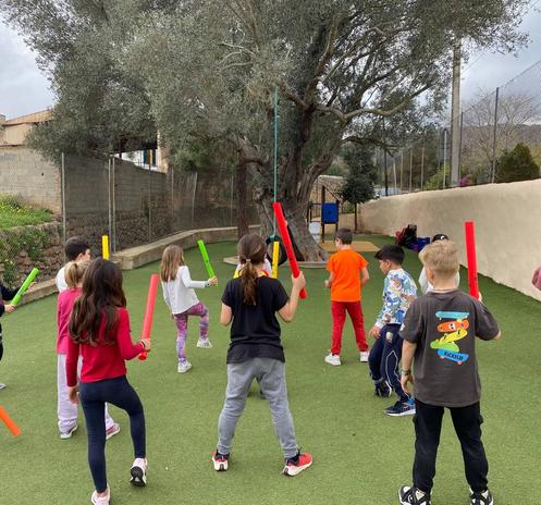 Un grup d'infants utilitza el set de percussió al pati de l'escola.