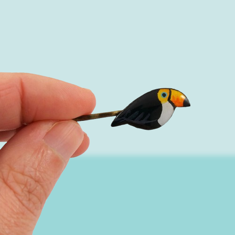 Épingle à cheveux avec un petit toucan réalisé en CD recyclé, peint à la main net recouvert de résine époxy.
La barrette est de couleur bronze, mais elle peut être argentée.