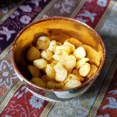 'Saikato', roasted pieces of rice dough coated in a mix of yuzu peel and sugar. Mimicking rapeseed flowers, water is added to the pieces to create a sweet drink.