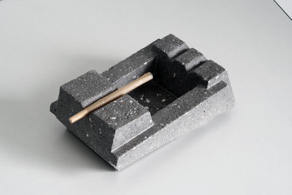 top view of an abstract geometric shaped ashtray. The ashtray is from concrete and is sanded down so specs of crushed shells and river sand appear on the surface resulting in a Terrazzo finish.