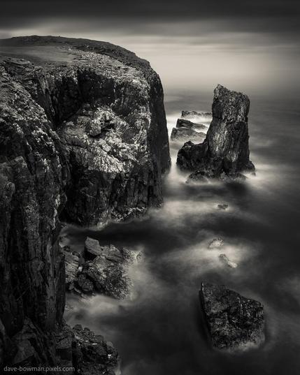 In this photograph taken at the Butt of Lewis on the Isle of Lewis, Scotland, UK, nature's raw power takes centre stage. The weather-beaten cliffs stand tall and imposing, etched with the marks of time and the relentless force of the elements. On this stormy day, the sea rages below, its turbulent waves crashing against the rocky shoreline. A long exposure captures the motion, creating an ethereal mist that veils the scene with a sense of both mystery and drama. Despite the tempestuous atmosphere, a subtle warmth permeates the image, adding a touch of comfort amidst the wild and rugged landscape. It's a mesmerising portrayal of nature's fury and beauty, inviting viewers to experience the majesty of this untamed coastal paradise.