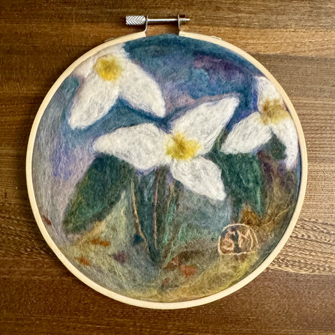 Needle felted trilliums on mixed colour background framed in embroidery hoop. Soft, impressionist style.