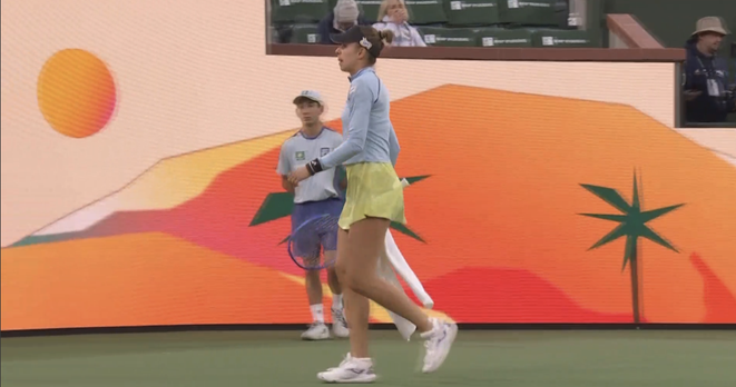 Magda Linette in profile as she finalizes her warmup and prepares to serve
